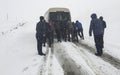 People pushing stuck car in snowy mountain Royalty Free Stock Photo