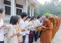 People put food offerings in a Buddhist monk's alms bowl to make