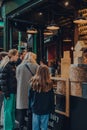 People queue at a cheese kiosk inside Borough Market in London, UK Royalty Free Stock Photo