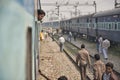 People on the railroad tracks between two parked trains at New Delhi train station