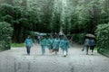 people in raincoats blur in the Park in the rain