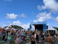 People raise arms into the air at Wanderlust MC Yogi Yoga Class at outdoor yoga class