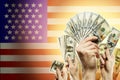 People raising hands with dollars and American flag on background. Patriotic concept Royalty Free Stock Photo