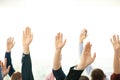 People raising hands to ask questions at business training on light background