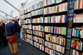 People reading and buying books inside a bookstore with bookshelves Royalty Free Stock Photo