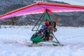 People ready to make flight on ski motor glider in winter on snowy forest background