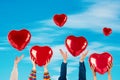 People with red heart balloons