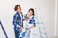 People, redecoration and relationship concept - Young funny couple doing renovation in new apartment Royalty Free Stock Photo