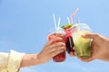 People with refreshing drinks against blue sky