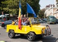 People rejoice in the yellow car hung with flags on Independence Day of the Republic of Moldova