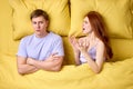 people, relationship difficulties and family concept - unhappy couple having conflict in bed at home, male ignoring wife Royalty Free Stock Photo