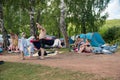 People relax in nature with the whole family with a tent among the trees on the lake in summer