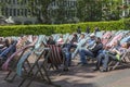 People relax in sun loungers in front of the National Theater on the South Embankment