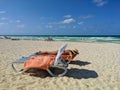 Woman in a hat lies on a blue chaise longue on a towel and admires the azure ocean. Cayo Coco, Cuba Royalty Free Stock Photo