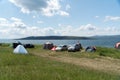 People relax in a tent camp on the shore of a Large lake in the summer