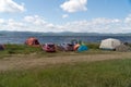 People relax in a tent camp on the shore of a Large lake in the summer season