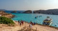 People relaxing in Blue Lagoon, with ferry and boats in turquoise water