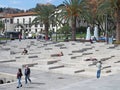 People relaxing on the concrete steps of the waterside park in the center of funchal city madeira