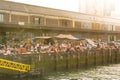 People relaxing and enjoying the sun on the quay of Kattendrecht, in front of Fenix Food Factory in Rotterdam.