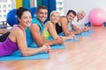 People relaxing on exercise mats in fitness studio Royalty Free Stock Photo