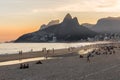 Sunset at Ipanema beach with people & tourists on beach with Dois IrmÃÂ£os Two Brothers mountains in background in Rio de Janeiro Royalty Free Stock Photo