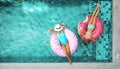 People relaxing on inflatable ring in pool