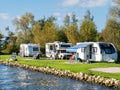 People relaxing near motorhomes on campsite in Earnewald, Alde Feanen, Friesland, Netherlands