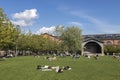 People relaxing in the New Holland island of the city, modern hipster place to spend weekend. Green lawn is full of families with