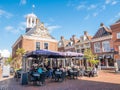 People on outdoor terrace of grand cafe in historic weigh house in old town of Dokkum, Friesland, Netherlands