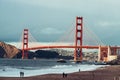 People relaxing and walking on ocean beach near Golden Gate bridge in San Francisco. Royalty Free Stock Photo