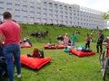 People rest on red inflatable mattresses placed on the green grass