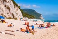 People resting on amazing white pebbles beach surrounded by high massive white limestone rocky cliffs meeting Adriatic sea