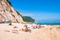 People resting on amazing white pebbles beach surrounded by high massive white limestone rocky cliffs meeting Adriatic sea