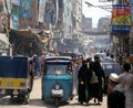 People and rickshaws in a busy street in Peshawar, Pakistan