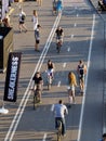 People ride bicycles and scooters in the park on a bicycle track