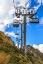 People ride on chair ski lift of Gorky Gorod mountain resort on autumn Caucasus mountains background. Sochi, Russia Royalty Free Stock Photo