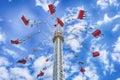 people on a ride going up to the top of the ride on a sunny day with clouds in the sky Royalty Free Stock Photo