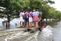 People ride their vehicles through the flooded roads