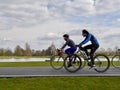 People riding bicycles in Bushy Park with Diana Fountain in the background. London, UK.