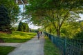 People riding bicycles on a path, under green trees. A place for relaxation and activities. Pittsburgh, Pennsylvania, USA