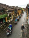 People riding cyclos on main road at Ancient town in Hoi an, Vietnam