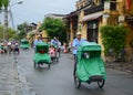 People riding cyclos on the main street in Hoi An, Vietnam
