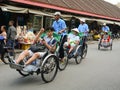 People riding cyclos on the main street in Hoi An, Vietnam