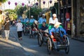 People riding cyclos on street in Hoi An, Vietnam Royalty Free Stock Photo