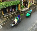 People riding cyclos on street in Hoi An, Vietnam