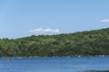 People riding in kayaks and canoe on Sheppard lake, forest in the background and blue sky, New Jersey Botanical Garden Royalty Free Stock Photo