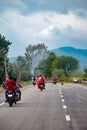 People riding motorbikes on the local roads of India, vertical