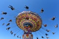 People riding on spinning swing carousel in amusement park