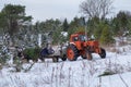 People riding in tractor trailer with cut fir, spruce and pine trees at a Christmas tree farm market.