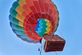 People rise into the air in the basket of a huge multi-colored balloon
